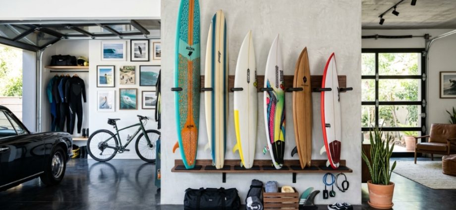 Vertical wood wall rack holding three surfboards inside a bright room.